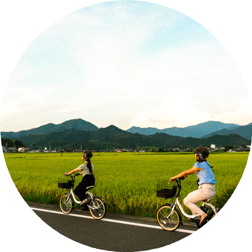 田んぼ道を自転車で走る子ども